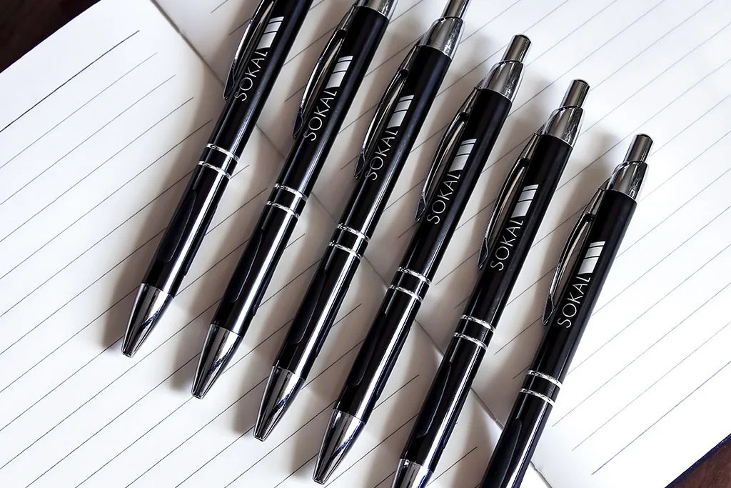 Collection of customized metal pens on a light surface