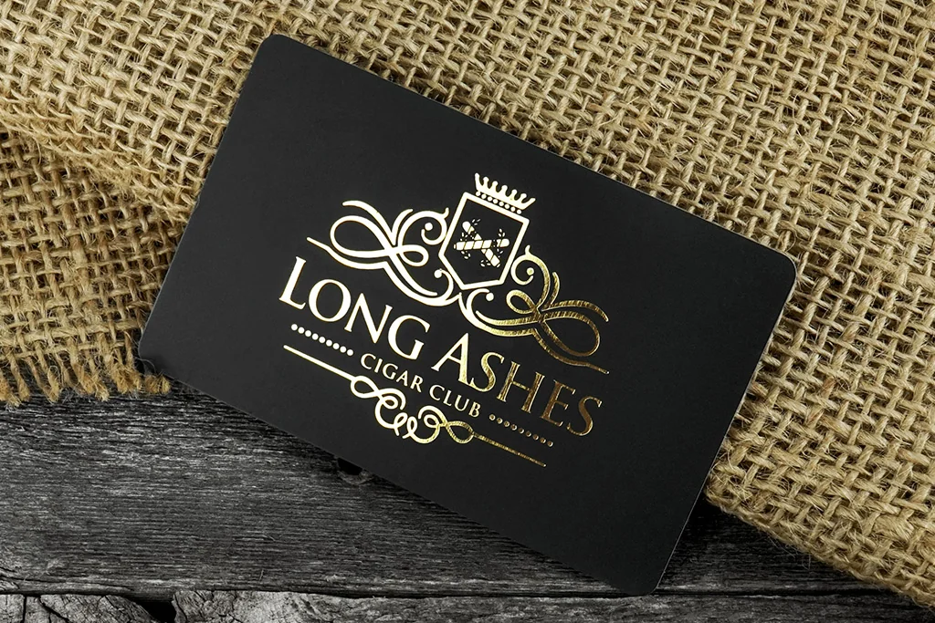 Black matte plastic business card with gold-tone artwork