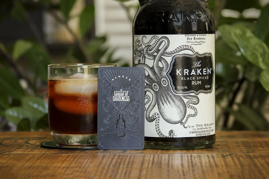 Black metal cutout card displayed with distillery bottle and glass